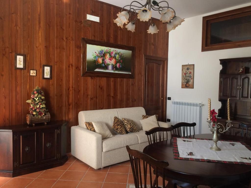 a living room with a couch and a table at Maison Il Colle in Rivisondoli