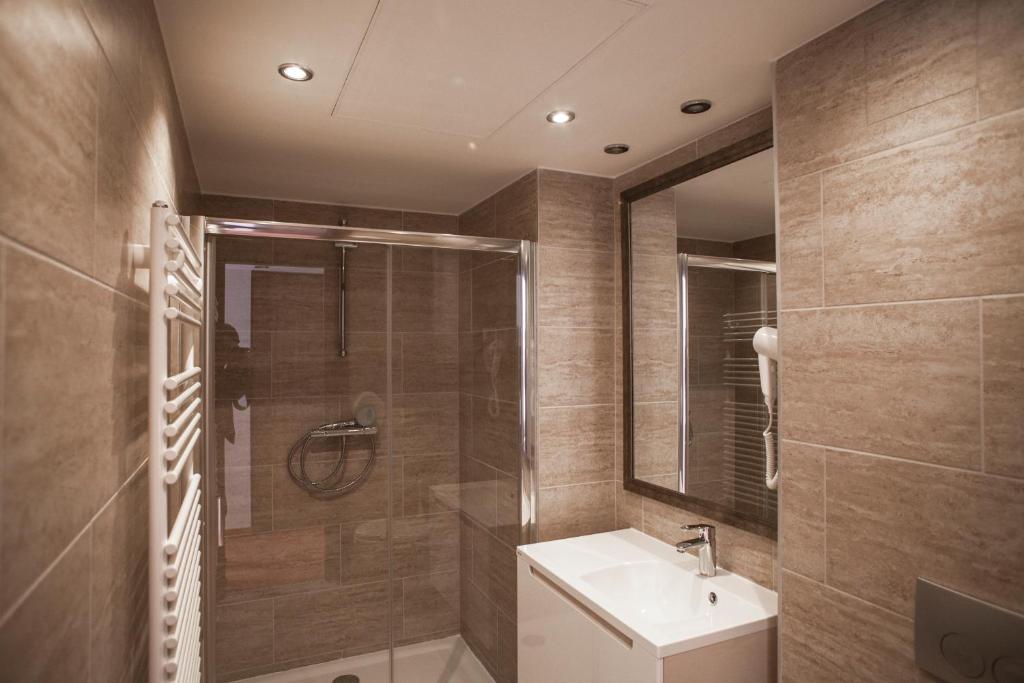 a bathroom with a sink and a shower at Bükkös Hotel & Spa in Szentendre