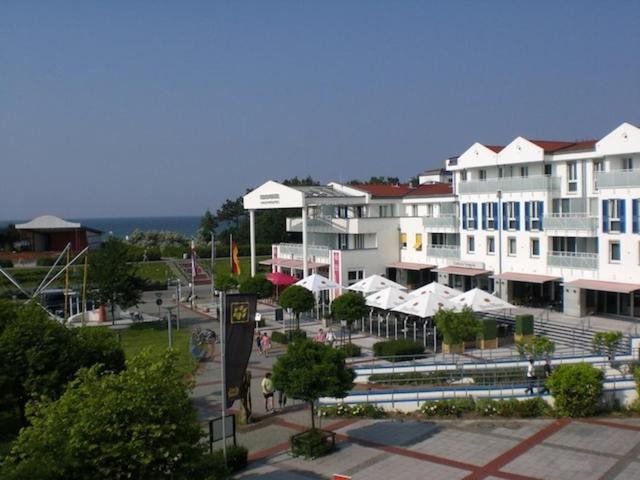 a large white building with umbrellas in a town at Komfortapartment Zingster-Meerblick in Zingst