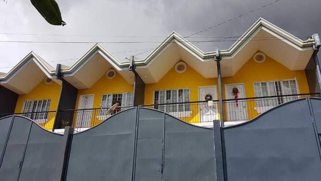 a yellow house with a ramp in front of a house at Diodeth's Holiday Apartment in Butuan