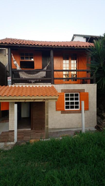 a house with an orange roof and a palm tree at Chalé Canez 1 in Farol de Santa Marta