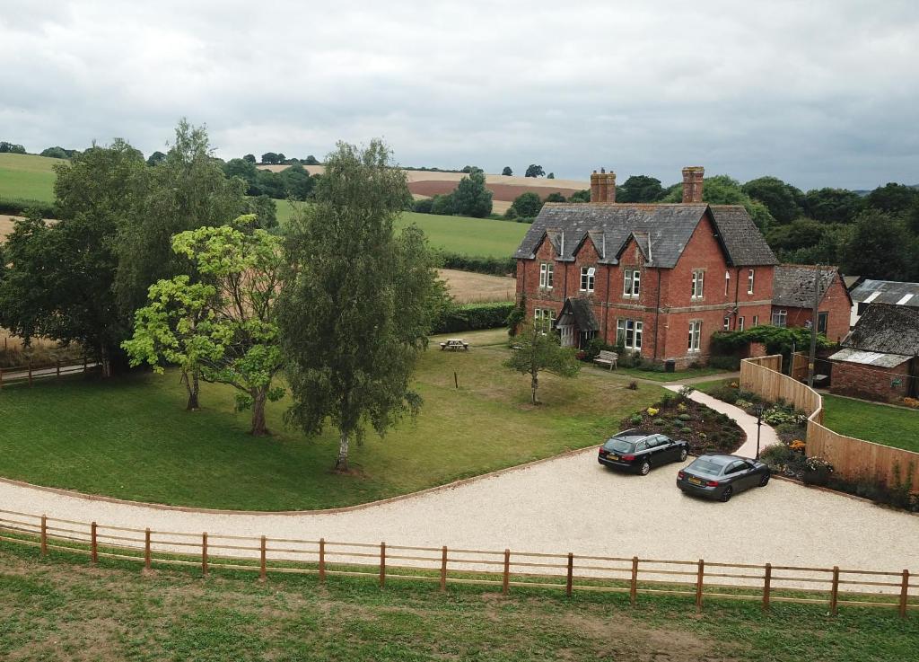 an aerial view of a house with two cars parked in a driveway at Newcourt Barton in Cullompton