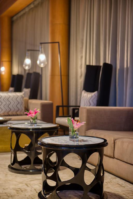 a living room with two tables with flowers on them at Azaya Beach Resort Goa in Benaulim