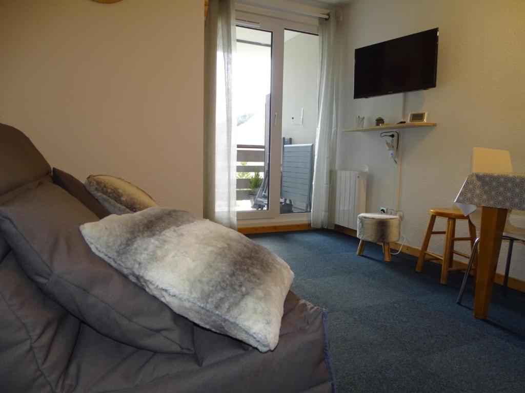- un salon avec un canapé et un oreiller dans l'établissement L'AnsloBoys Montagne A2, à Les Deux Alpes
