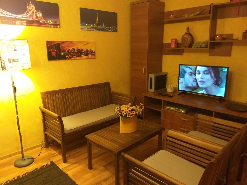 een woonkamer met een bank en een televisie bij Apartament Sonia ARHB 3 camere in Boekarest