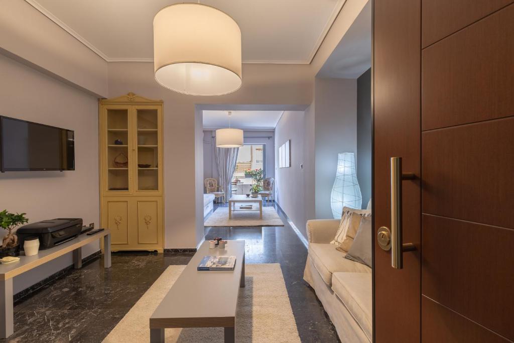 a living room with a couch and a table at Tranquil Central Apt, behind Athens Caravel Area in Athens