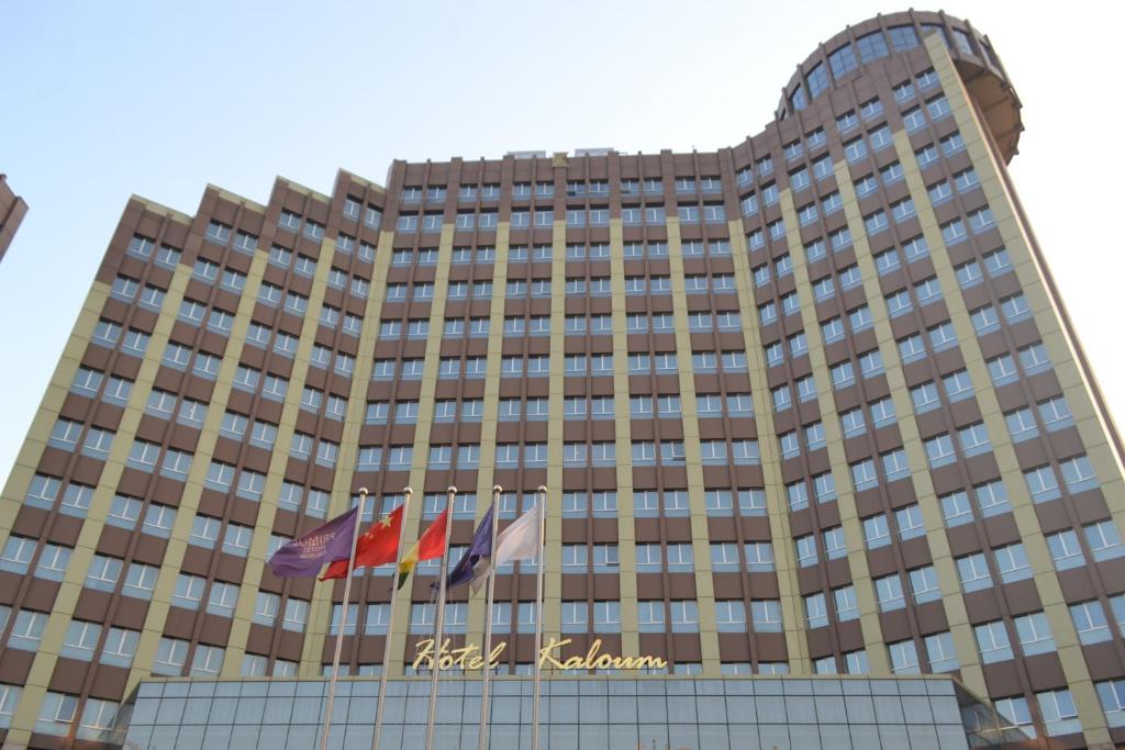 ein Hotelgebäude mit Flaggen davor in der Unterkunft Hotel Kaloum in Conakry