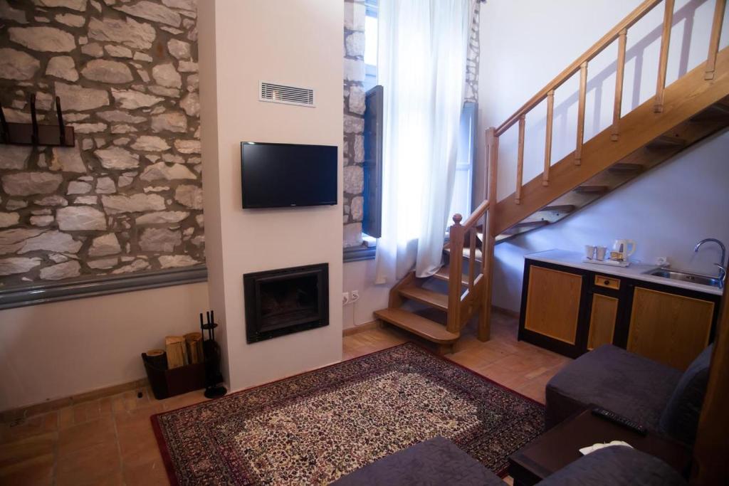a living room with a fireplace and a tv on a wall at 1821 En Dolianis in Áno Dholianá