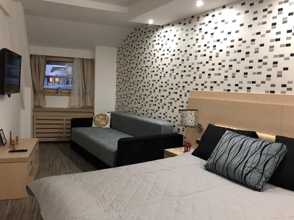 una habitación de hotel con una cama y un sofá en Apartmani Air, en Kopaonik