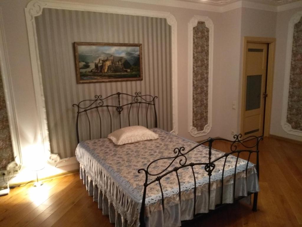 クラスノゴルスクにあるApartment On Pavshinkiy Bulvarのベッドルーム1室(ベッド1台付)が備わります。壁には絵画が飾られています。