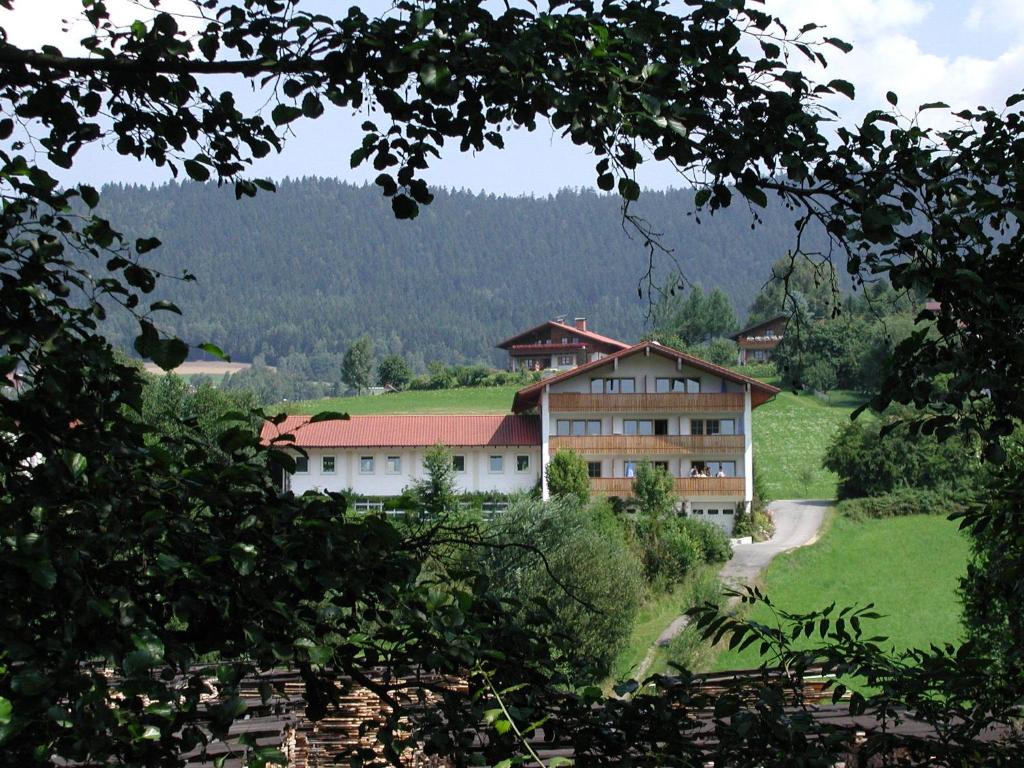 ein Gebäude inmitten eines Feldes mit Bäumen in der Unterkunft Appartmenthaus Moos Bäu in Lam