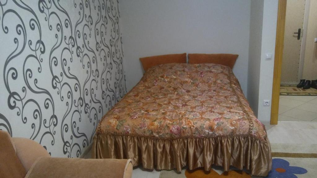 スモレンスクにあるApartamenty na Yubileynoyのベッドルーム1室(模様入りの壁のベッド1台付)