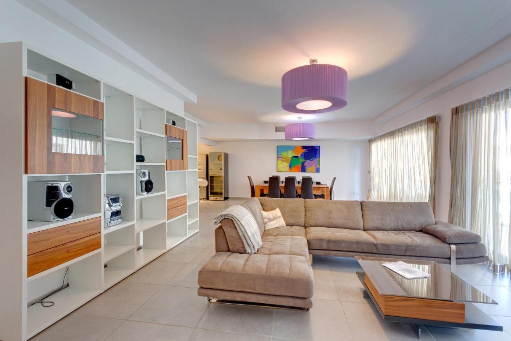 een woonkamer met een bank en een tafel bij Seaview Apartment In Fort Cambridge, Sliema in Sliema