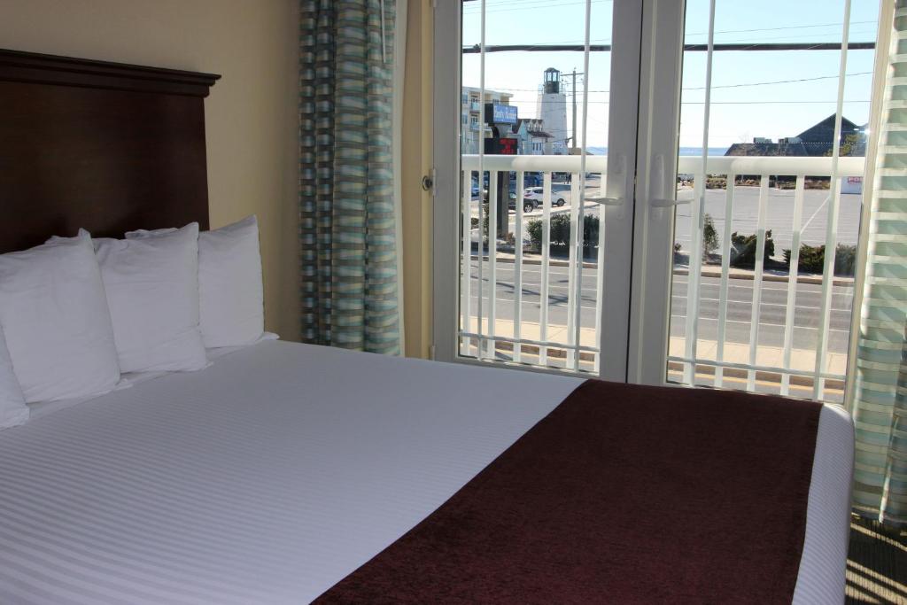 ein Schlafzimmer mit einem Bett und einem großen Fenster in der Unterkunft Gold Leaf Hotel of Dewey in Dewey Beach