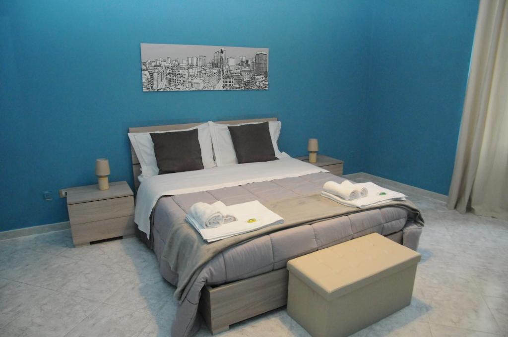 een slaapkamer met een groot bed met blauwe muren bij Same as home in Caserta