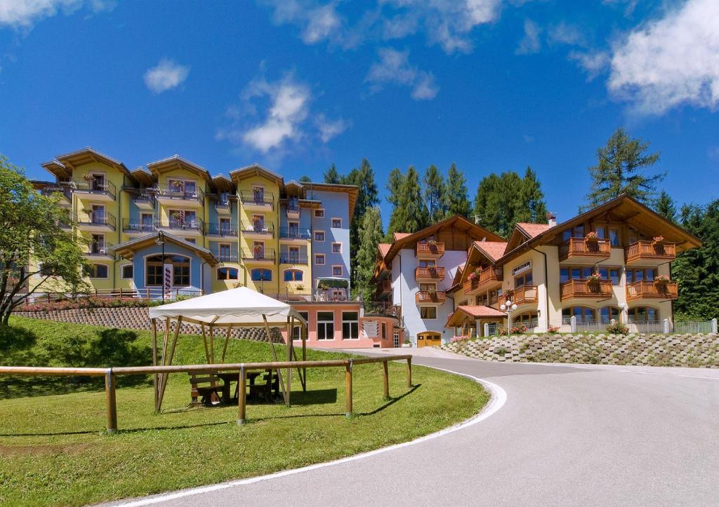 - un grand immeuble avec une table de pique-nique devant dans l'établissement Hotel Negritella, à Folgarida