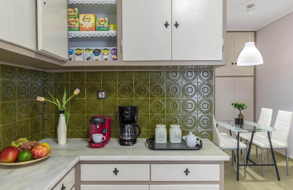 a kitchen with white cabinets and a table with a blender at Tranquil Central Apt, behind Athens Caravel Area in Athens