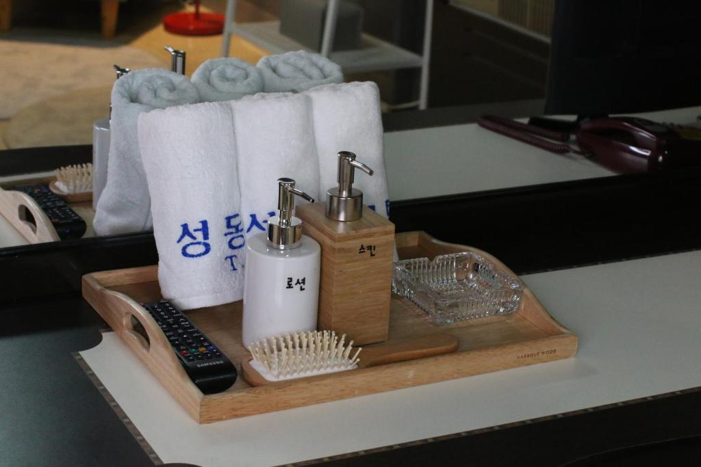 uma bandeja de madeira com papel higiénico e toalhas num balcão em Seong Dong Jang em Daegu