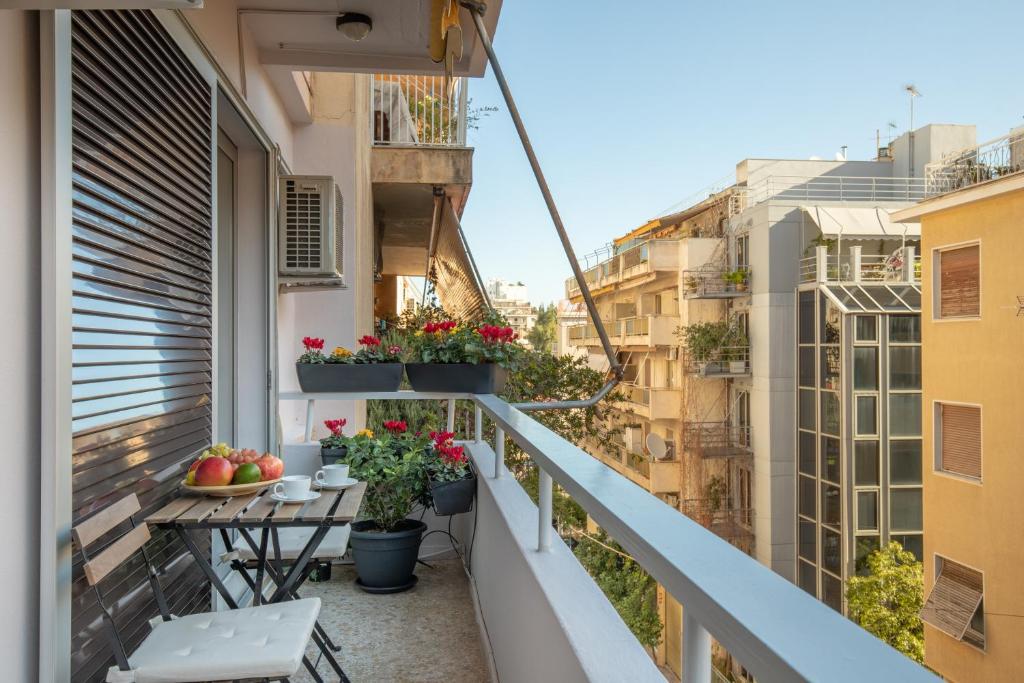 a balcony with potted plants and tables on a building at Tranquil Central Apt, behind Athens Caravel Area in Athens