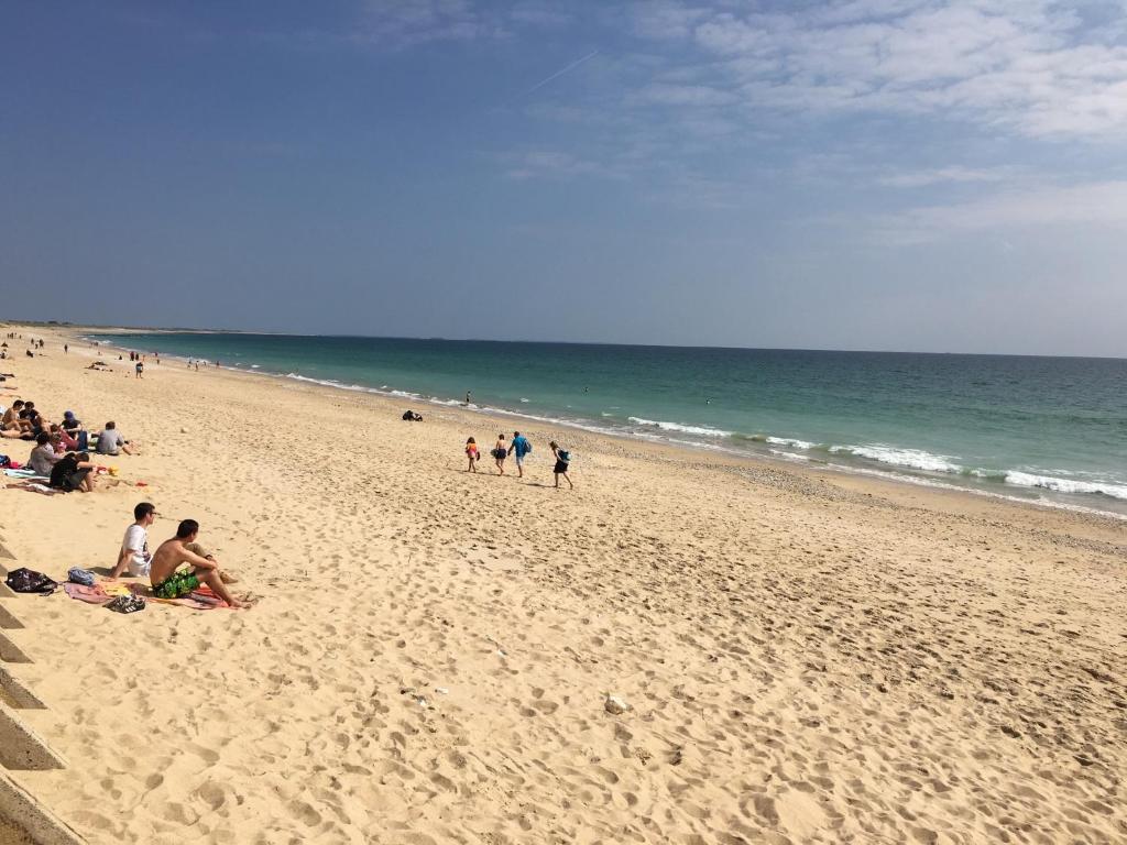 a group of people on a beach near the ocean at Kervran in Plouhinec