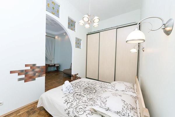 キーウにあるLuxury apartments in the center of old Kievのベッドルーム1室(白いシーツとランプ付)