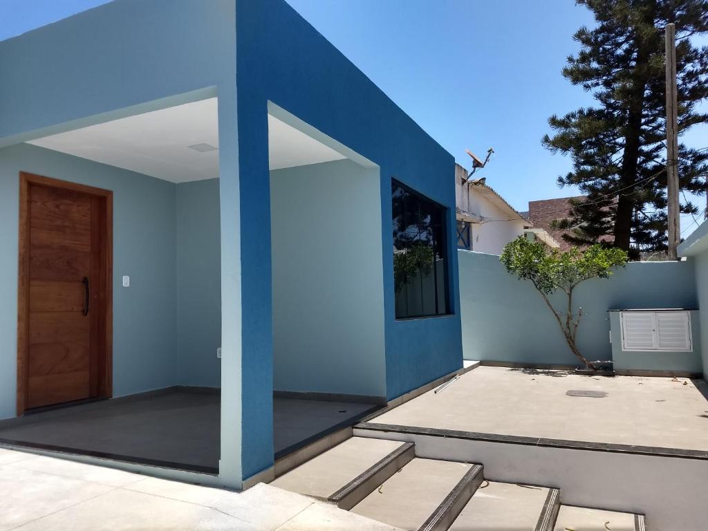 una puerta giratoria en una casa con una pared azul en Casa Praia dos Anjos, en Arraial do Cabo