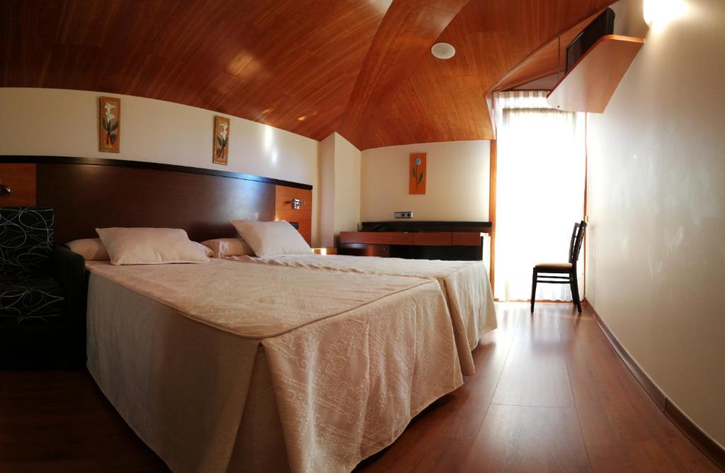 a bedroom with a large bed with a wooden ceiling at Doade in Hio