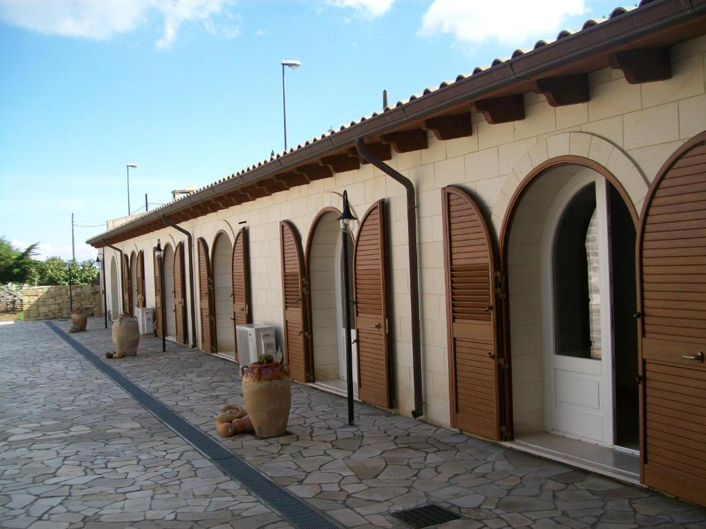 uma fila de arcos num edifício com portas castanhas em masseria Carlini em Acaya