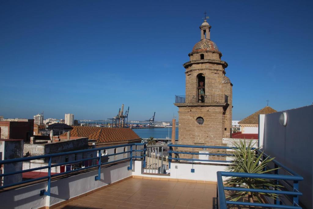 un bâtiment avec une tour d'horloge au-dessus d'un bâtiment dans l'établissement El Mirador del CAMPANARIO by Cadiz4Rentals, à Cadix