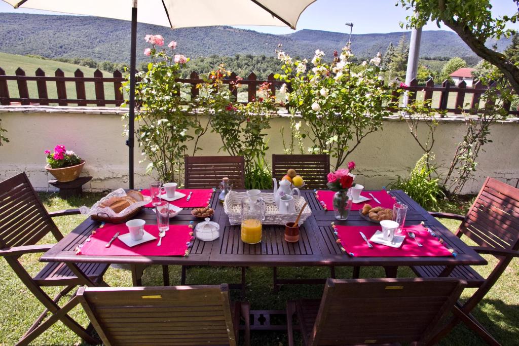 uma mesa de piquenique com guardanapos vermelhos e sumo de laranja em Casa Rural Lazkano en Sierra de Urbasa em San Martín