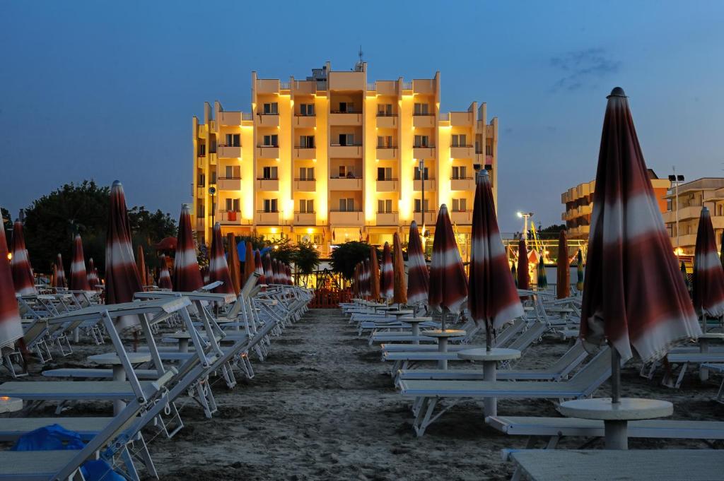 a row of chairs and umbrellas in front of a building at Hotel Life in Rimini