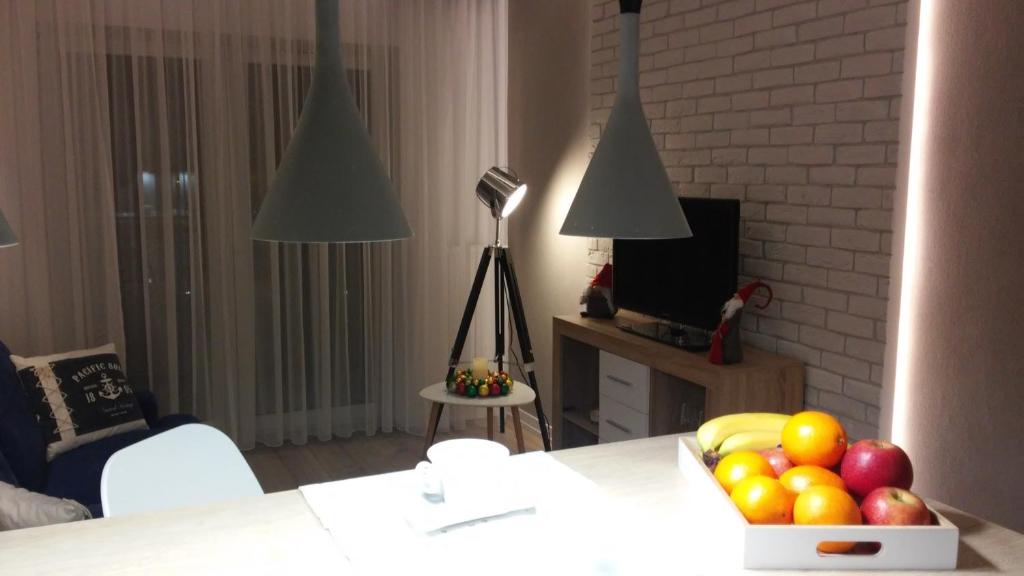 una sala de estar con una mesa con un bol de fruta en PANORAMA KOSZALIN, en Koszalin