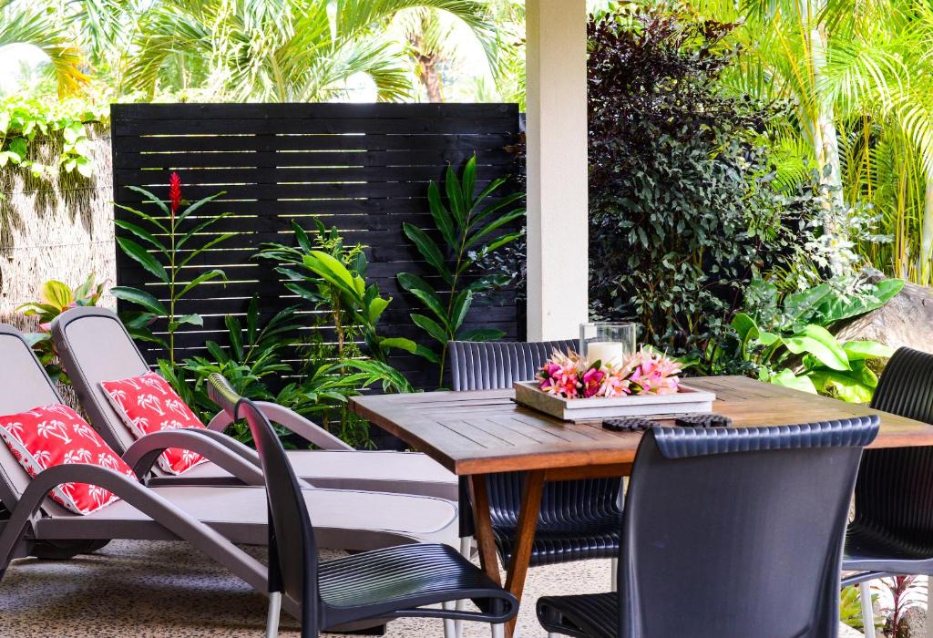 un patio con mesa de madera y sillas en Makayla Palms, en Rarotonga