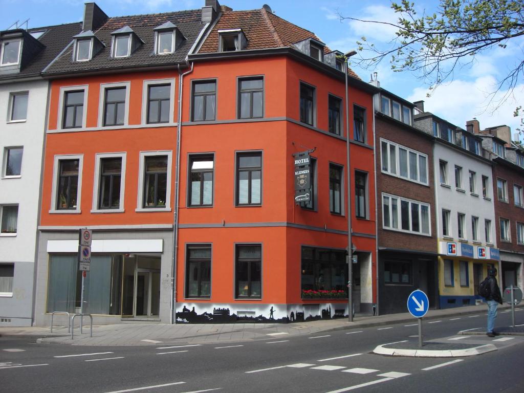 een oranje gebouw aan de straatkant bij Hotel Klenkes am Bahnhof in Aken