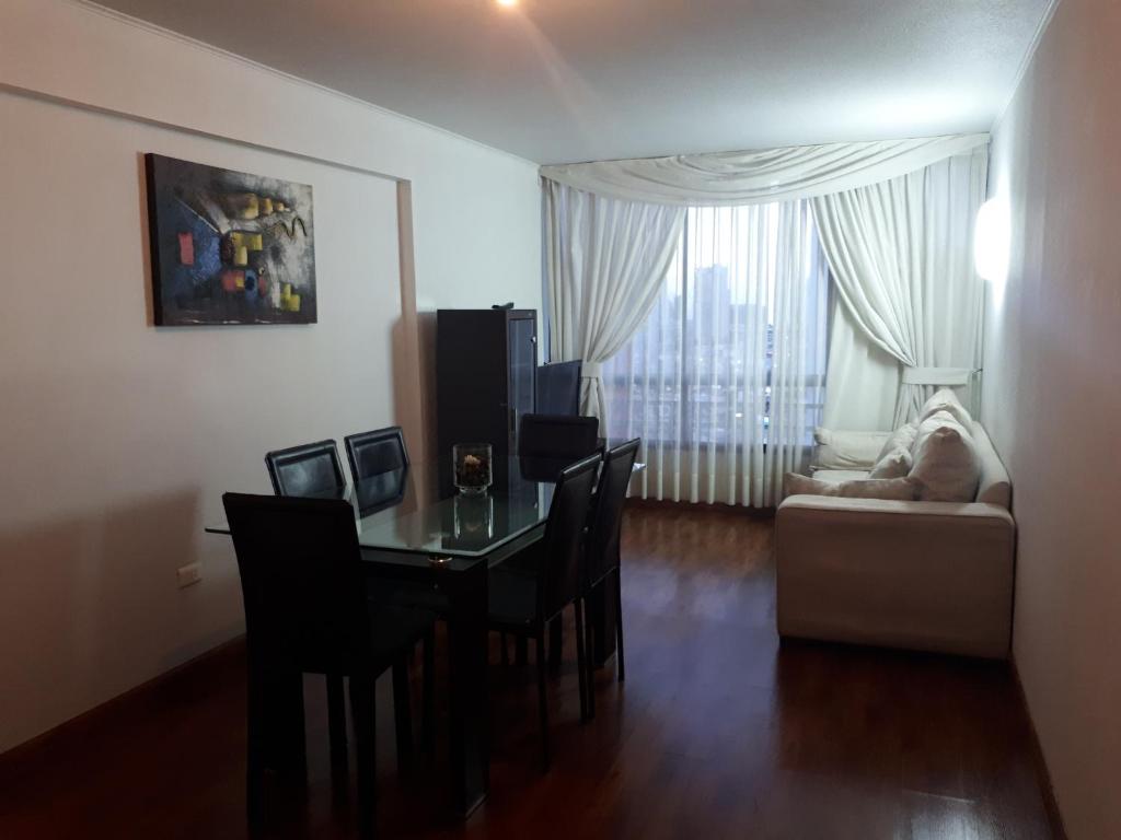 uma sala de estar com uma mesa e cadeiras e um sofá em Campanario 104 con factura em Iquique