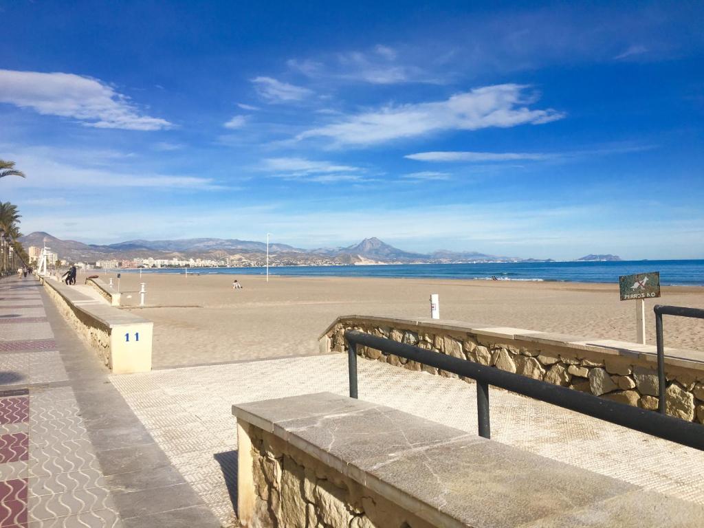 een uitzicht op een strand met de oceaan en de bergen bij Luxury 12th Floor Beachfront in El Campello