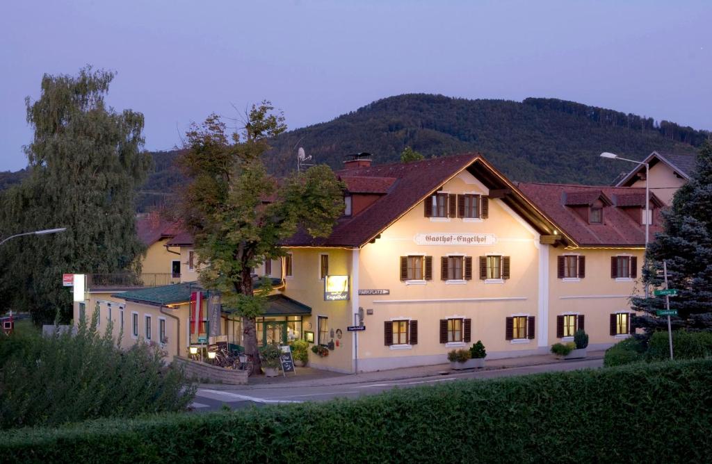 um grande edifício branco com uma montanha ao fundo em Gasthof Engelhof em Gmunden