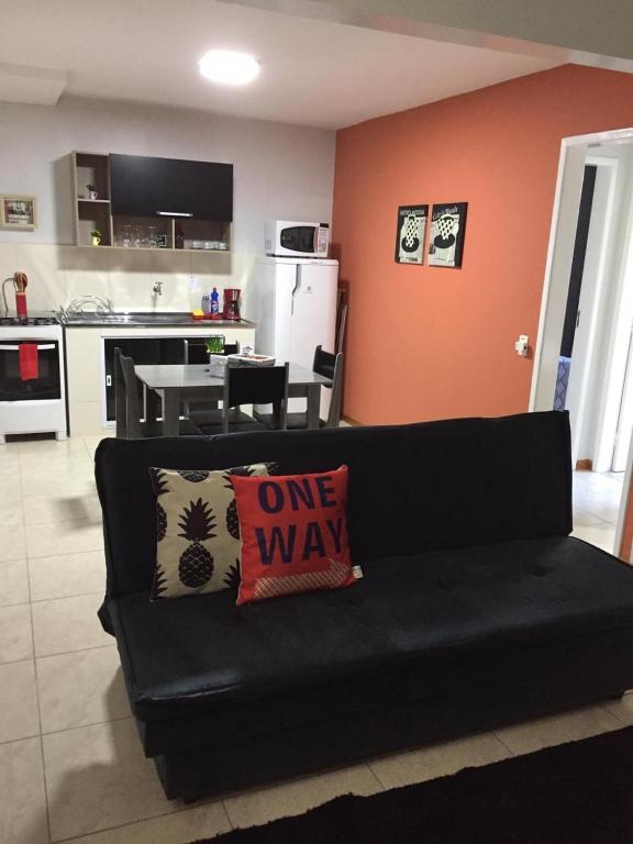 a black couch with a one way pillow on it in a kitchen at Apartamento Cantinho da Serra in Nova Friburgo
