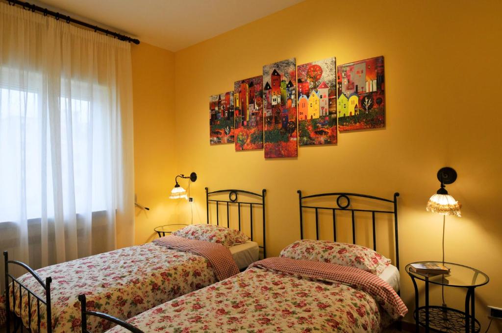 - 2 lits dans une chambre avec 2 affiches sur le mur dans l'établissement Casa Max, à Naples