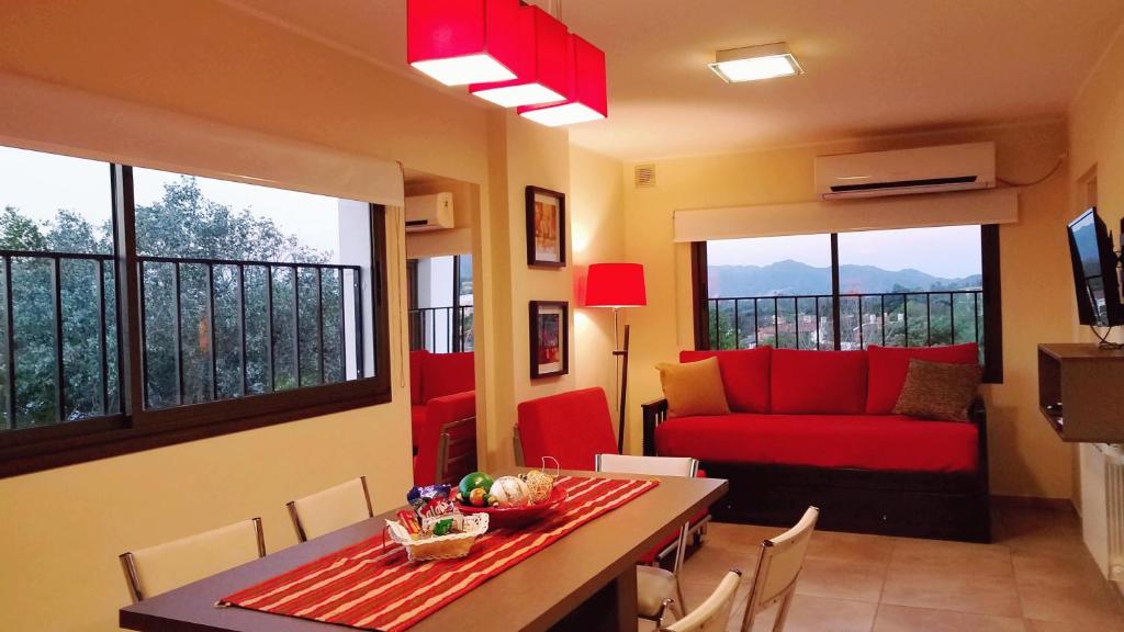 a living room with a red couch and a table at Edificio NIZA I in Villa Carlos Paz