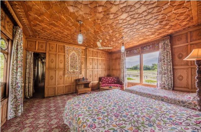 een grote slaapkamer met een groot bed en een bank bij S Group Of Houseboat in Srinagar