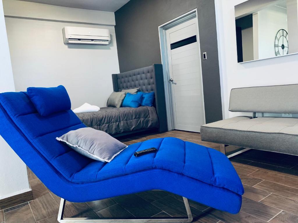 a living room with a blue chair and a couch at Modern Suite #2 Pasavento in Aguadilla