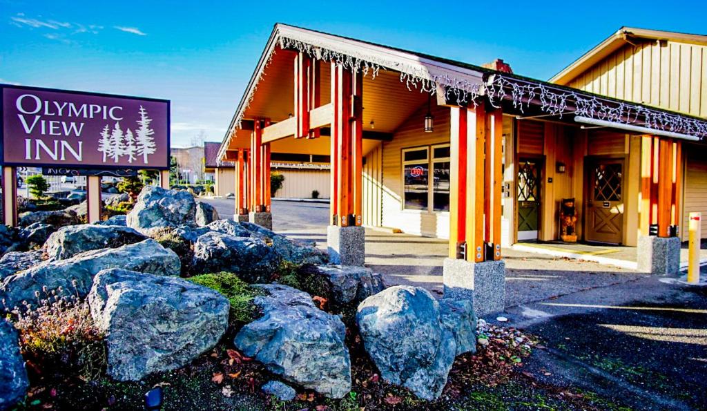 un cartello di fronte a un edificio con rocce di Olympic View Inn a Sequim