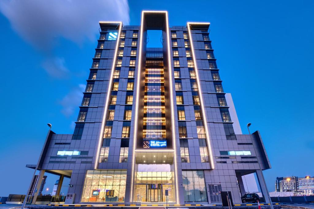 a tall building with its lights on at The S Hotel Al Barsha in Dubai