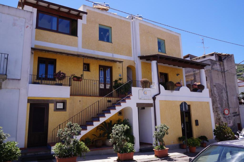 un edificio giallo e bianco con scale e piante di Casa Matarazzo a Città di Lipari