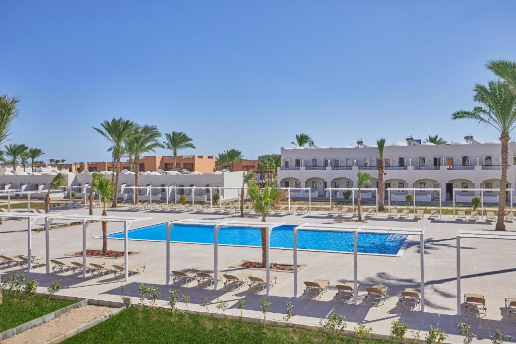 a resort with a pool and palm trees and a building at Solymar Reef Marsa in Coraya Bay