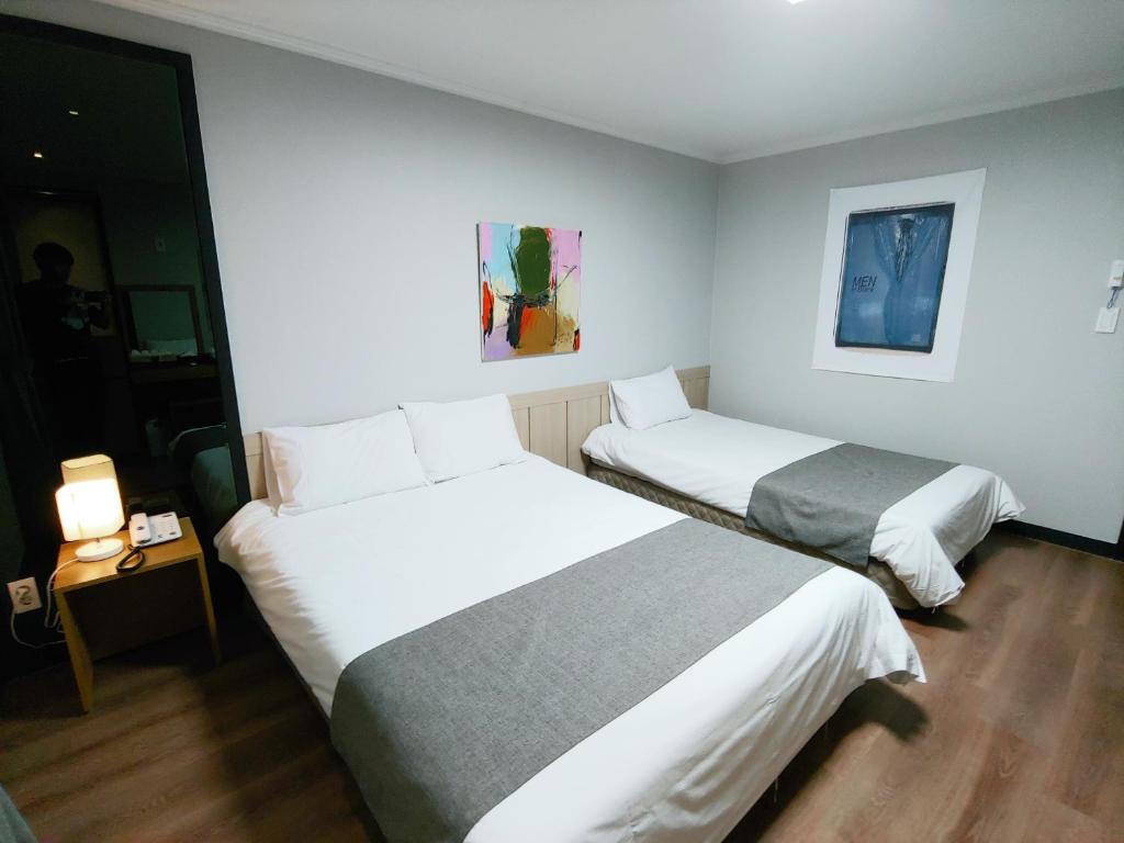 Postel nebo postele na pokoji v ubytování Hotel Tong Yeondong Jeju