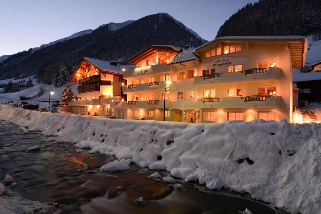 a hotel in the snow next to a river at Apart Garni Elfrieda in Ischgl