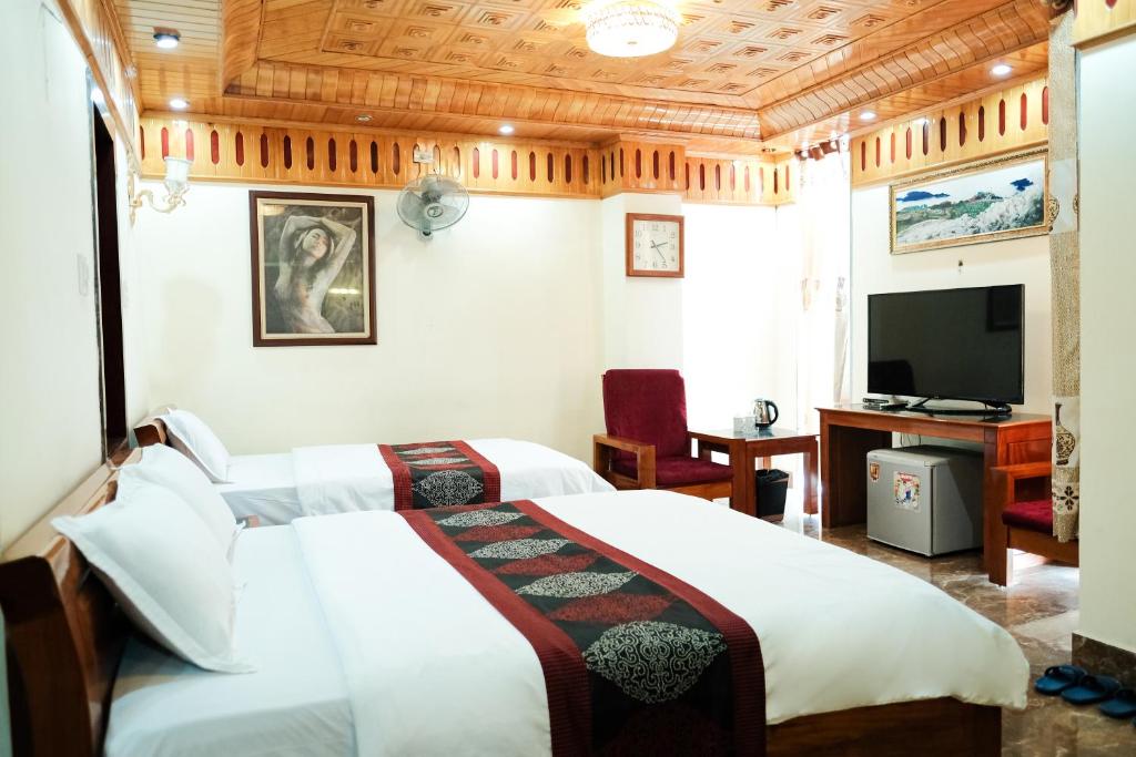 ein Hotelzimmer mit 2 Betten und einem TV in der Unterkunft Khách sạn TRIỆU KÝ VOÒNG in Lạng Sơn