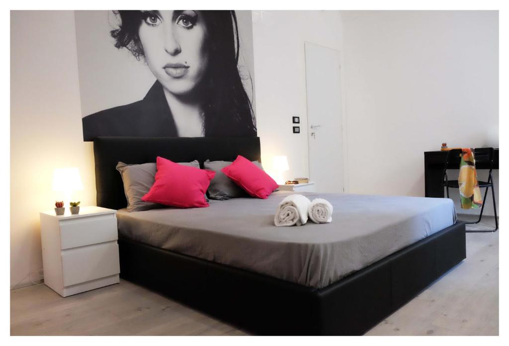 um quarto com uma cama com uma grande pintura na parede em B&B Elmi em Catânia